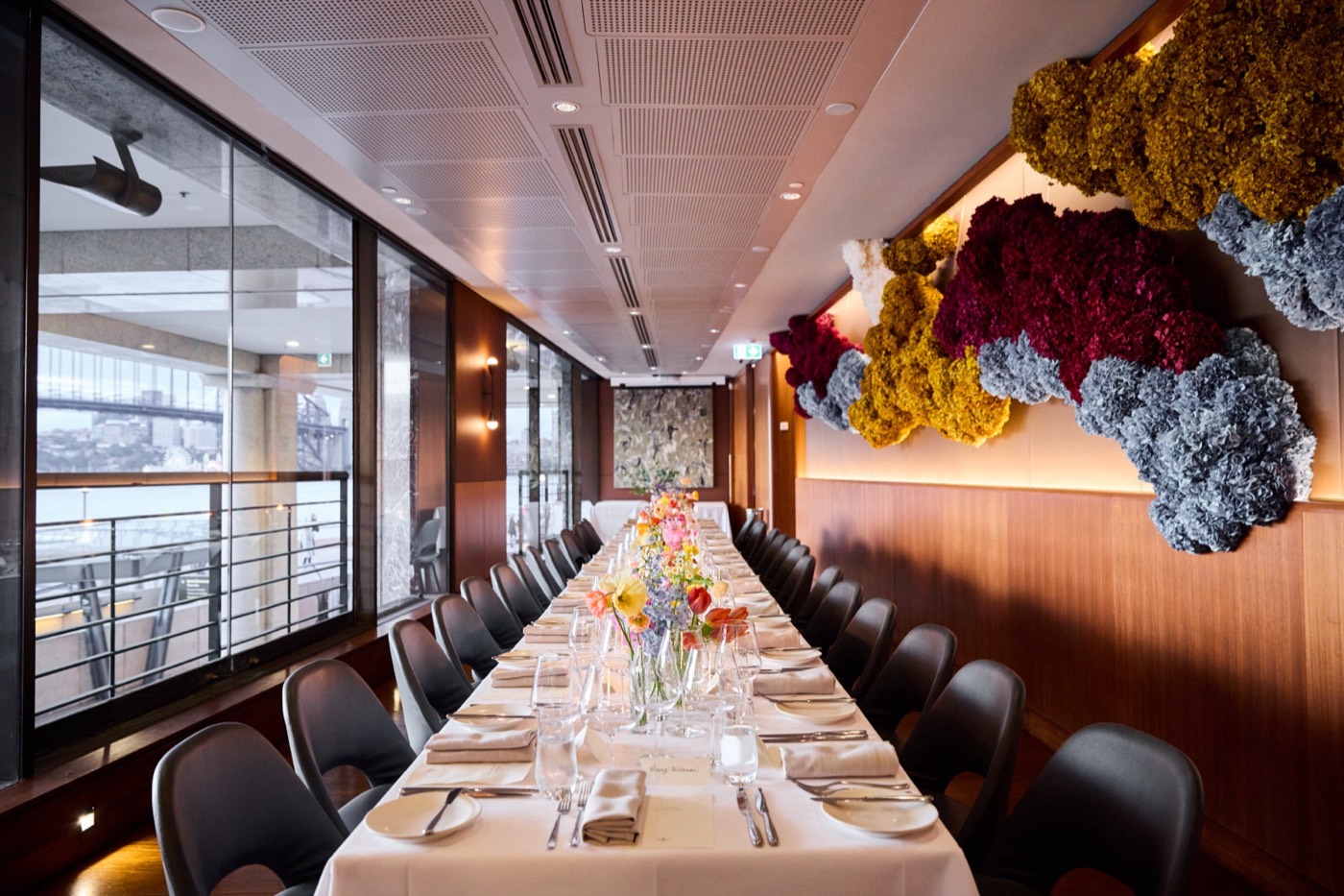 Aria's long private dining table beside windows overlooking Circular Quay