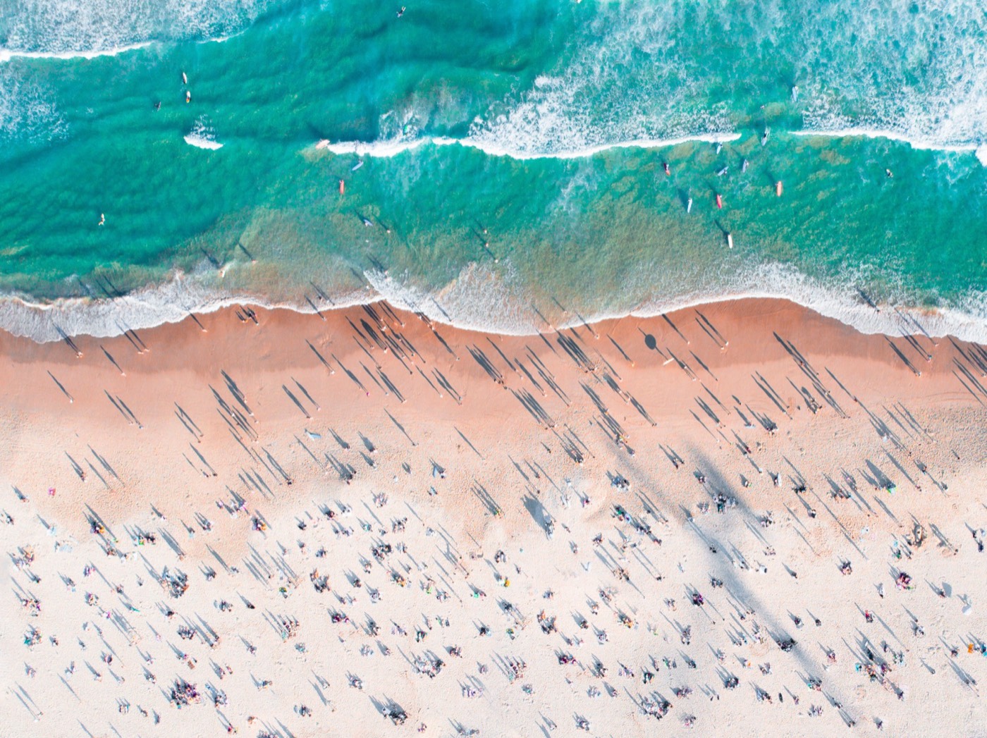 Aerial view of a crowded Bondi Beach with turquoise surf on a summer day