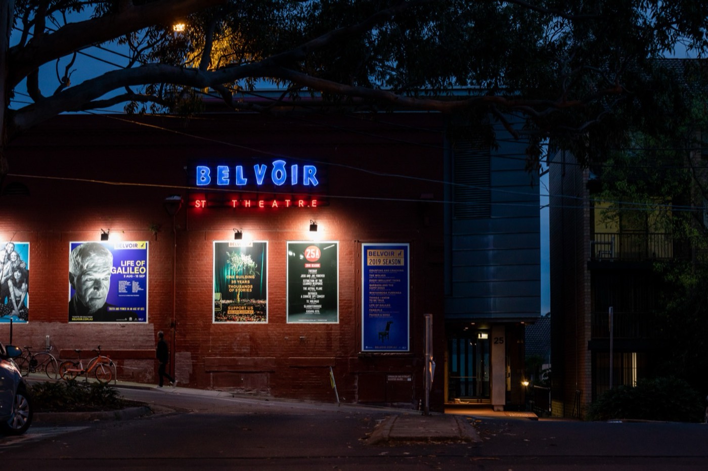 Belvoir St Theatre's neon sign and brick facade in Surry Hills at dusk
