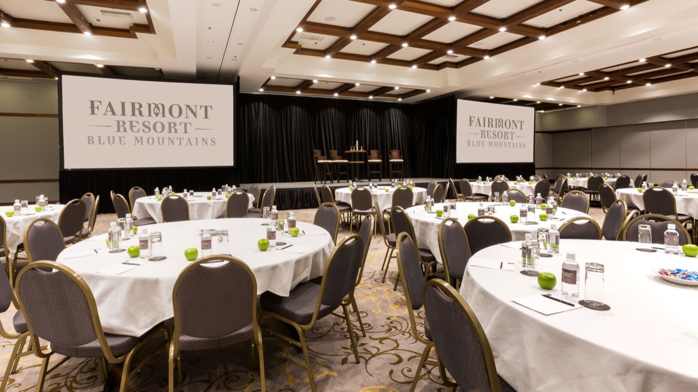 Fairmont Resort's Grand Ballroom set with round tables for a conference