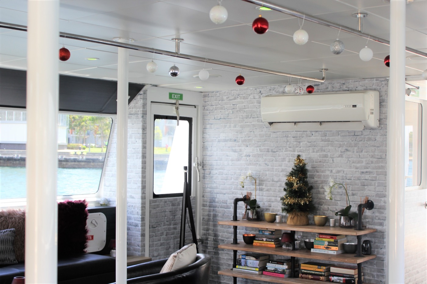 Lounge deck of the Fantasea Joy decorated with baubles and a small Christmas tree