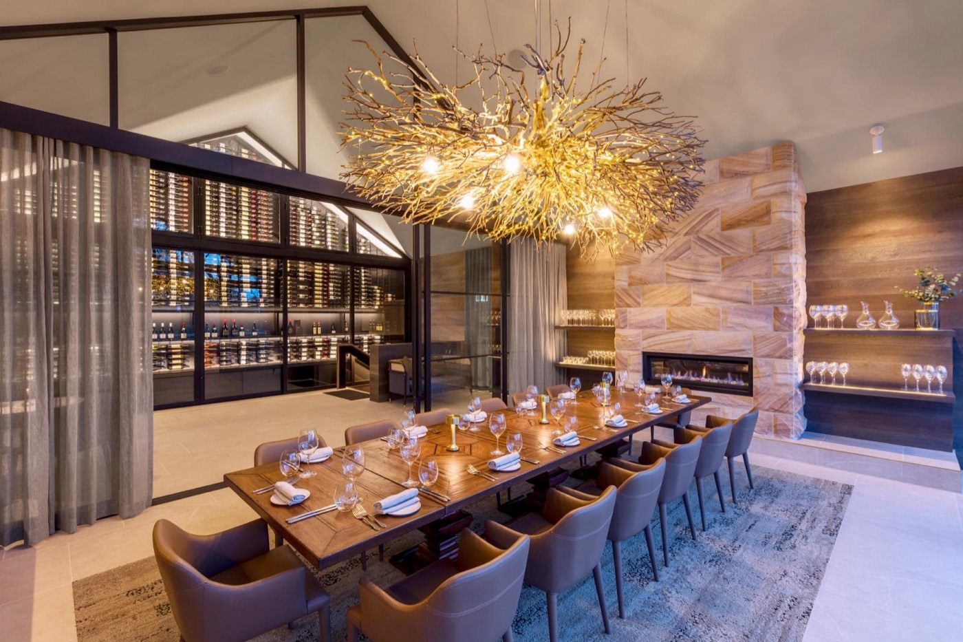 A private dining room at Spicers Guesthouse with a long table, wine wall and fireplace