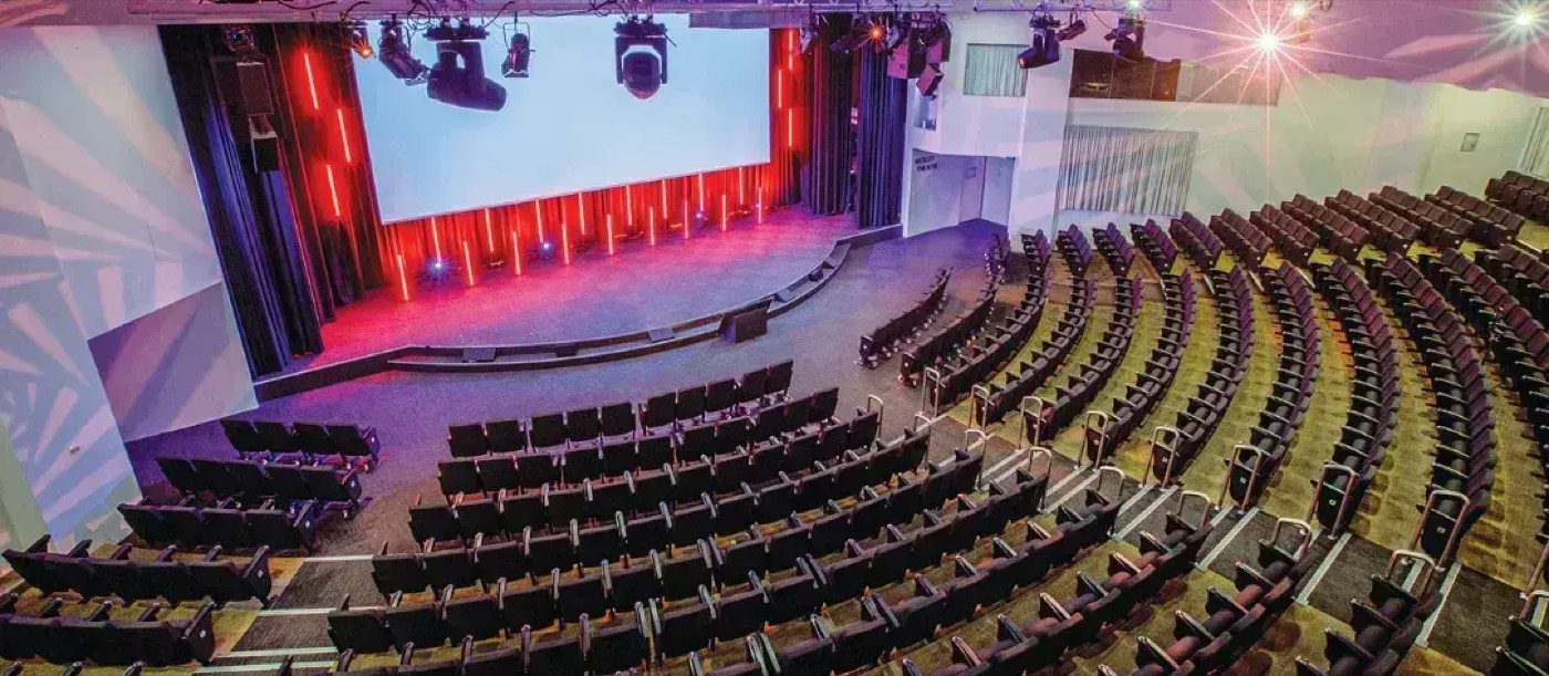 The tiered seating of the Wesley Theatre facing a lit stage