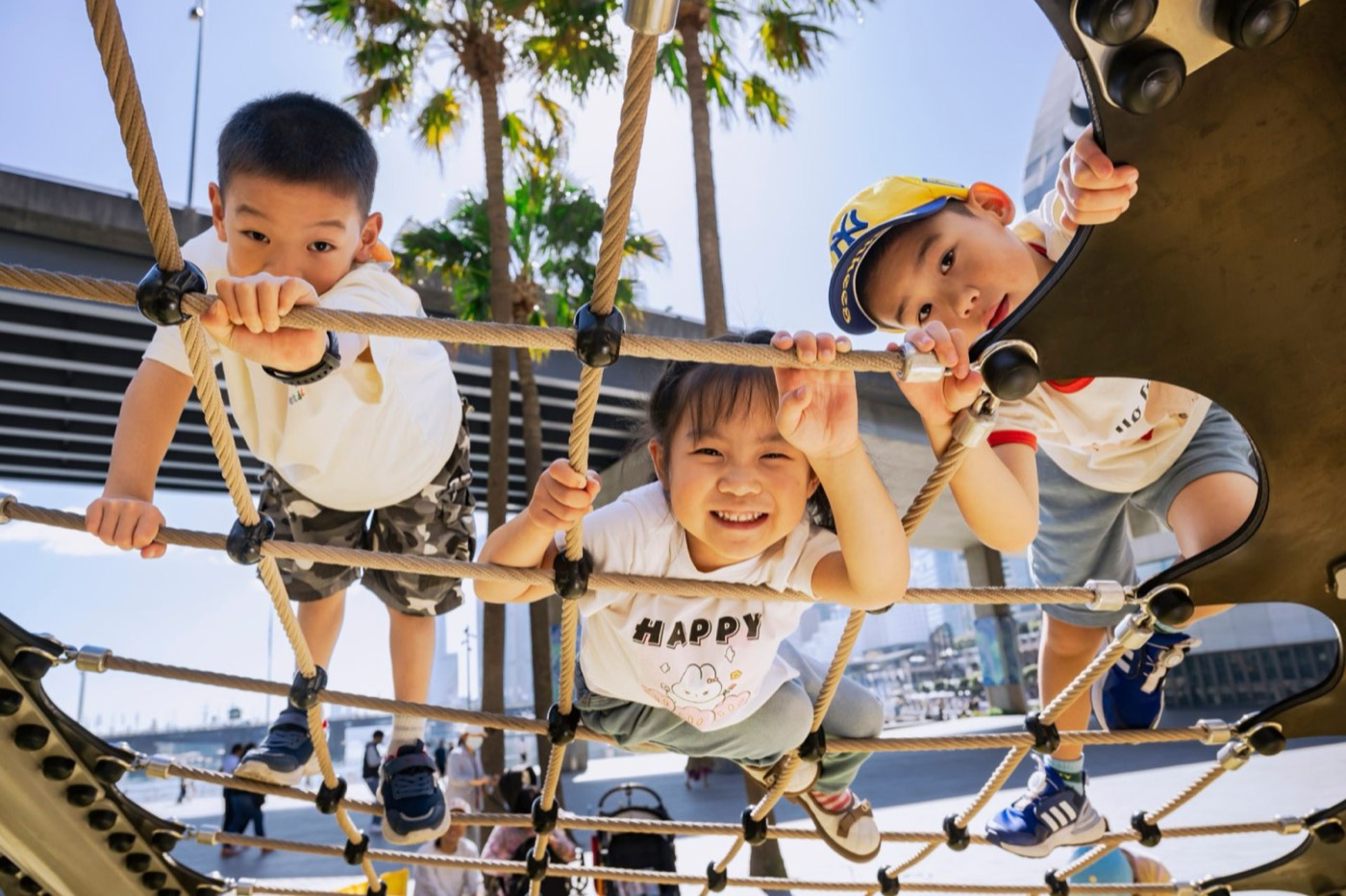 Children climbing a rope net at the Darling Quarter playground in Darling Harbour