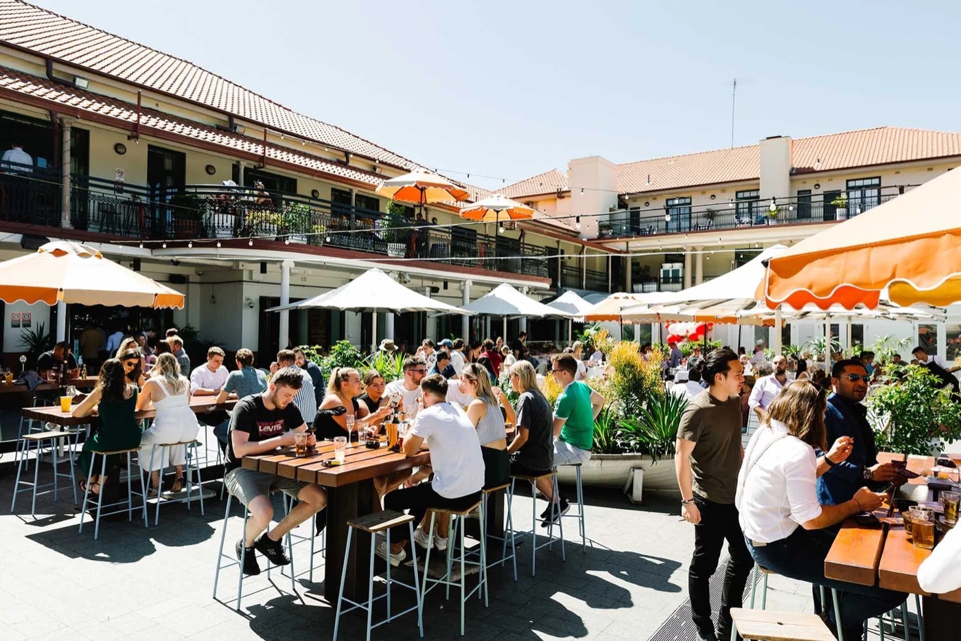 Crowded sunny beer garden with umbrellas at the Coogee Bay Hotel