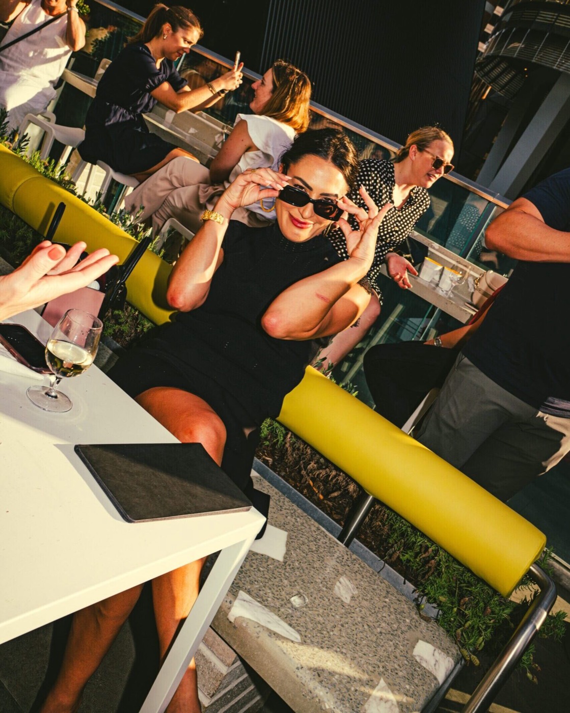 Friends at tables on the open-air rooftop at Jacksons on George