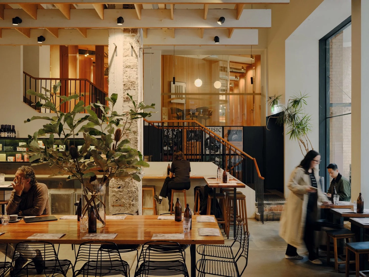 Long timber tables and plants inside Paramount Coffee Project in Surry Hills