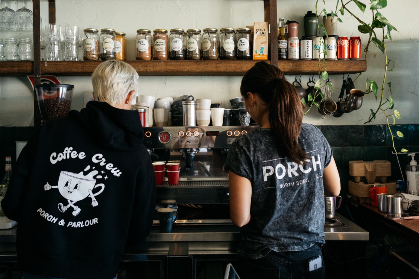 Baristas making coffee behind the counter at Porch & Parlour
