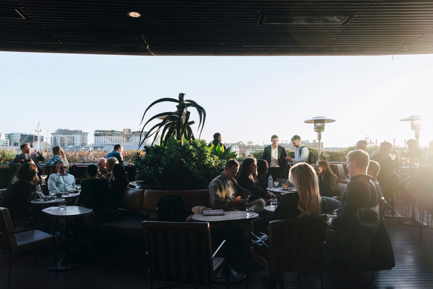 Drinkers at sunset on Smoke's rooftop terrace at Barangaroo House