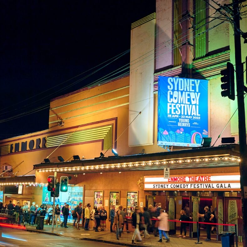 Art deco facade of the Enmore Theatre at night with crowds outside