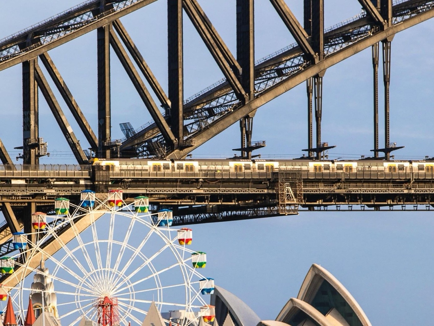 Luna Park's Ferris Wheel beneath the Sydney Harbour Bridge with the Opera House sails in front