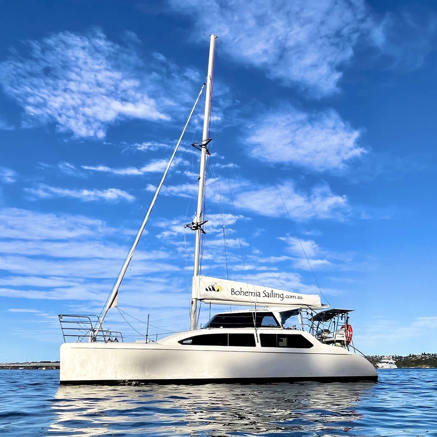 Bohemia Sailing's white catamaran at anchor under a blue sky