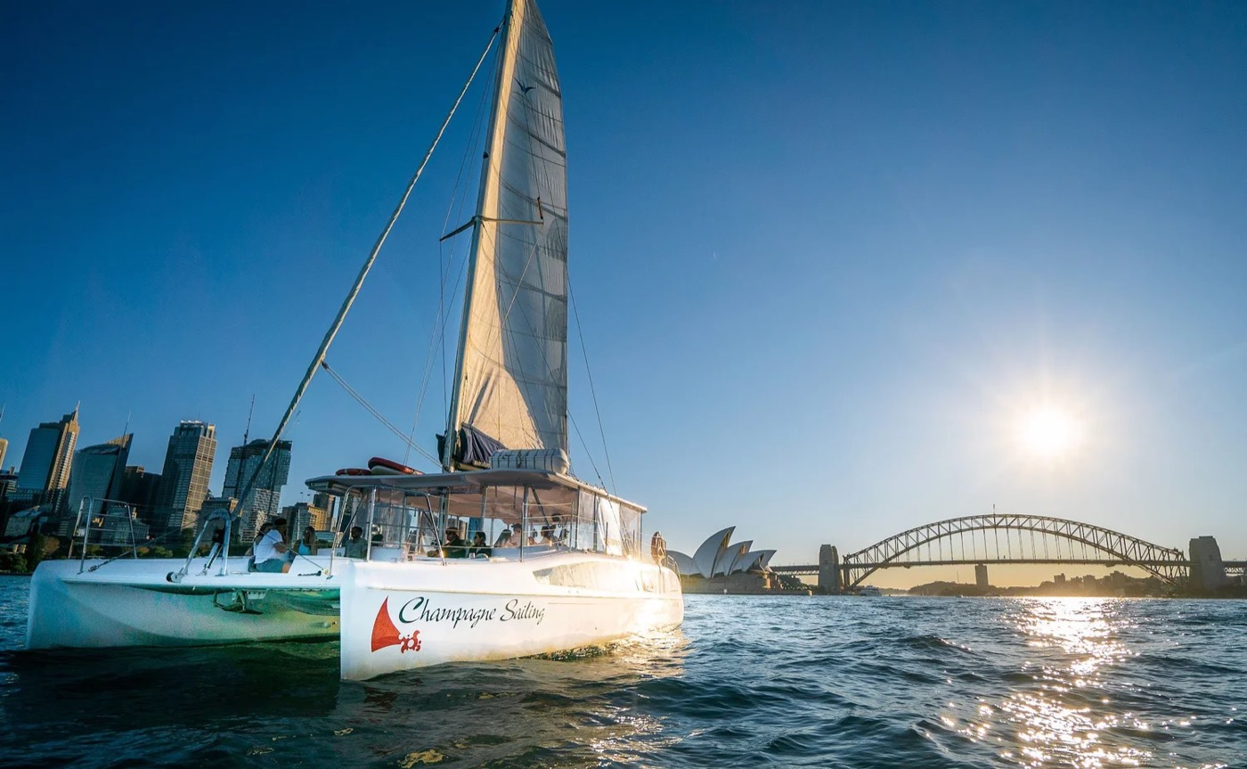 Champagne Sailing catamaran on Sydney Harbour with the Harbour Bridge and Opera House behind