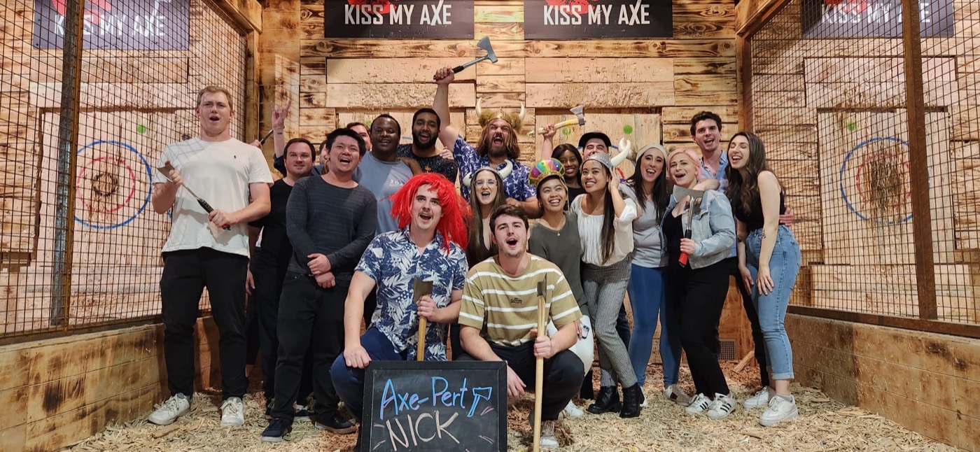 Group celebrating in an axe-throwing lane at Kiss My Axe