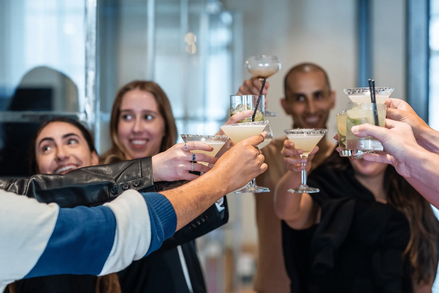 Guests raising freshly made cocktails at a Kubarz cocktail class