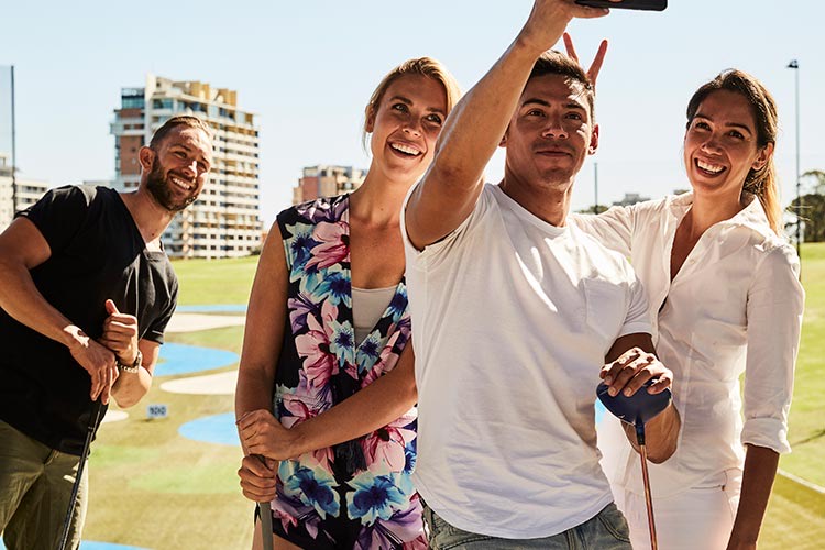 Friends with golf clubs taking a selfie at Moore Park Golf