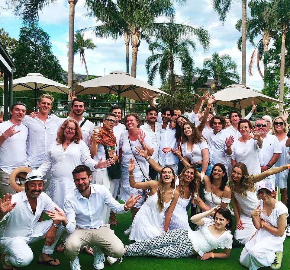 Large group dressed in white celebrating on the bowling green at The Neutral Bay Club