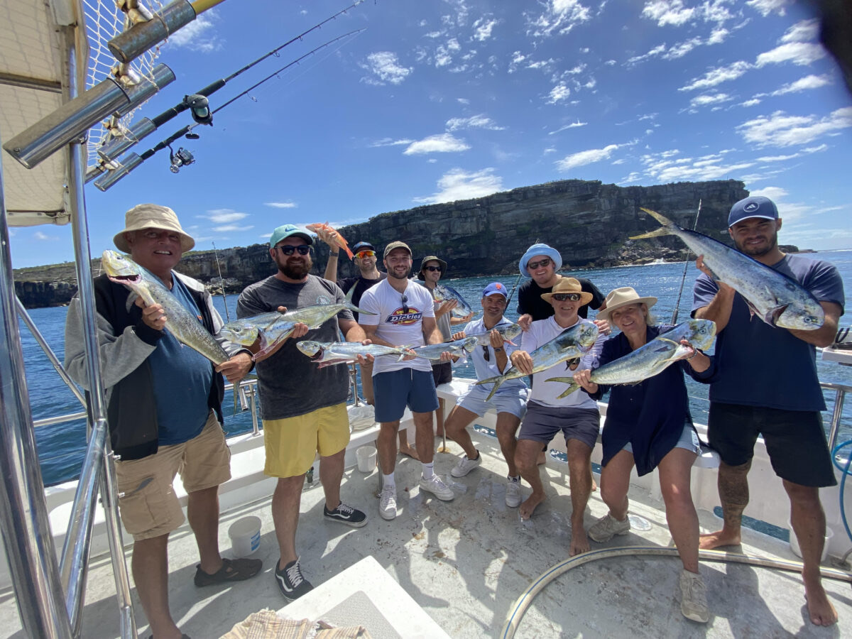 Group holding up their catch on a Sydney Charter Fishing boat near the Heads