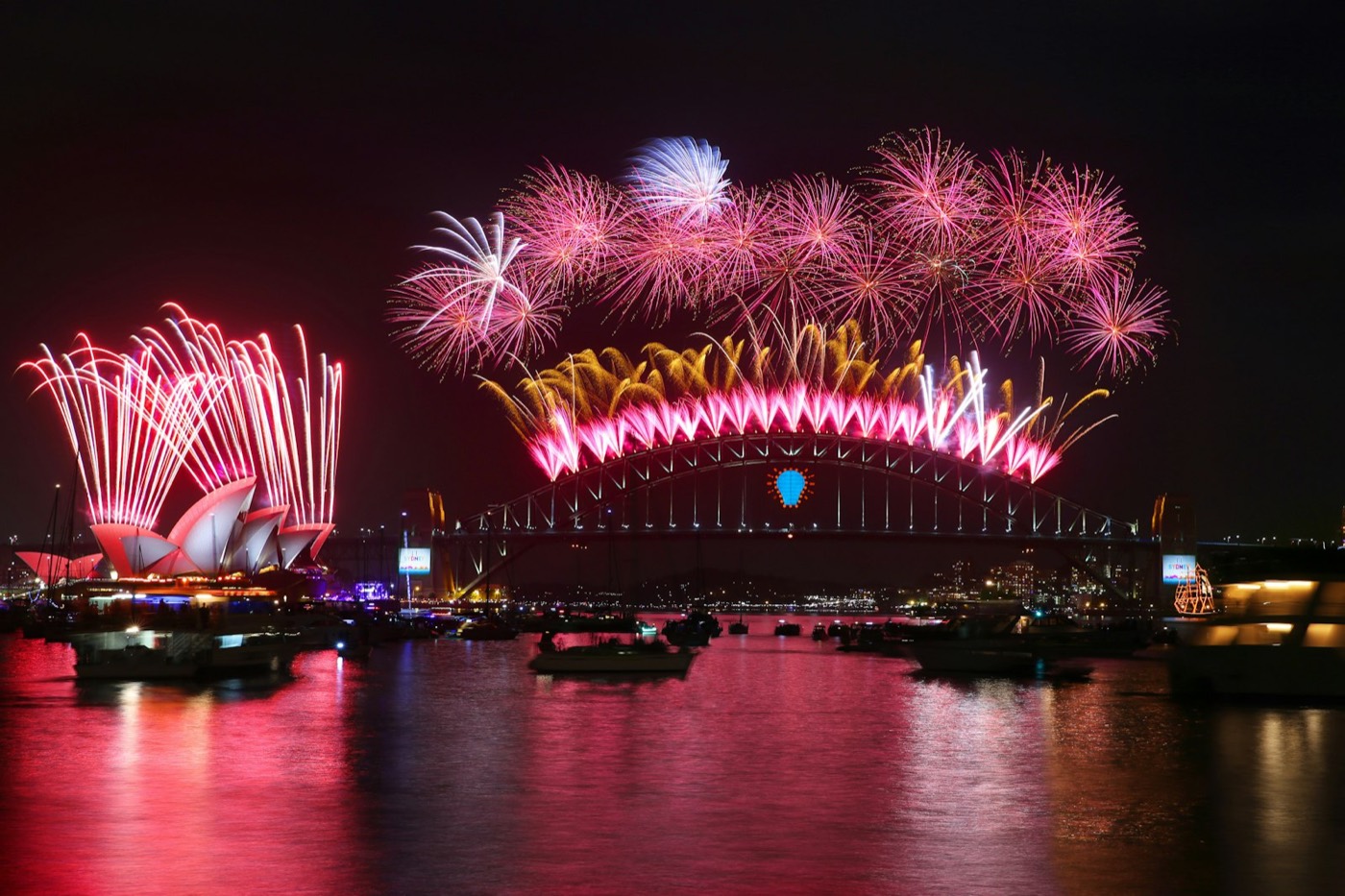Pink and gold fireworks bursting over the Sydney Opera House and Harbour Bridge