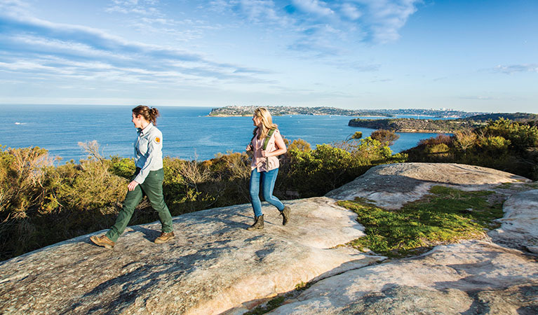 Walkers on sandstone at Dobroyd Head on the Spit Bridge to Manly walk, with ocean views