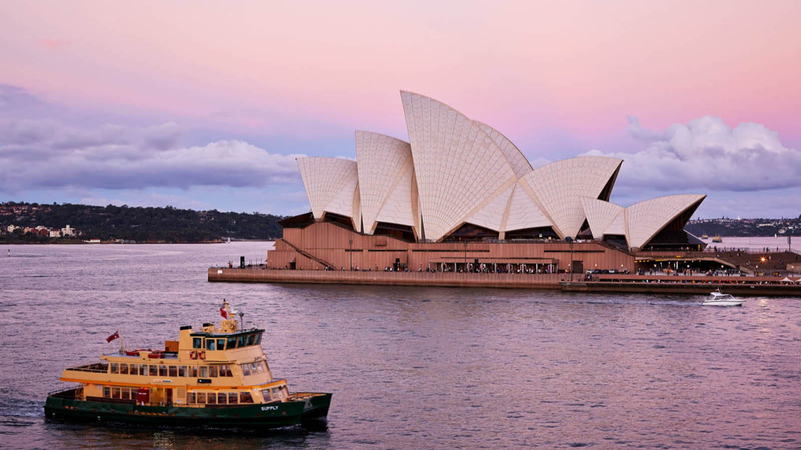 Sydney Opera House at dusk with a harbour ferry passing