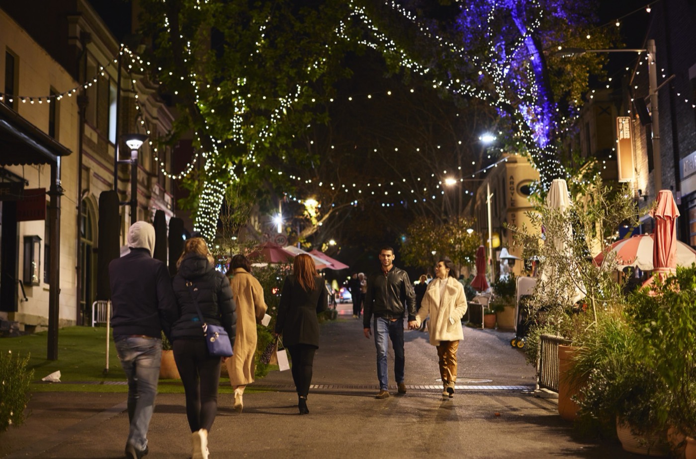 People strolling a fairy-lit street in The Rocks at night