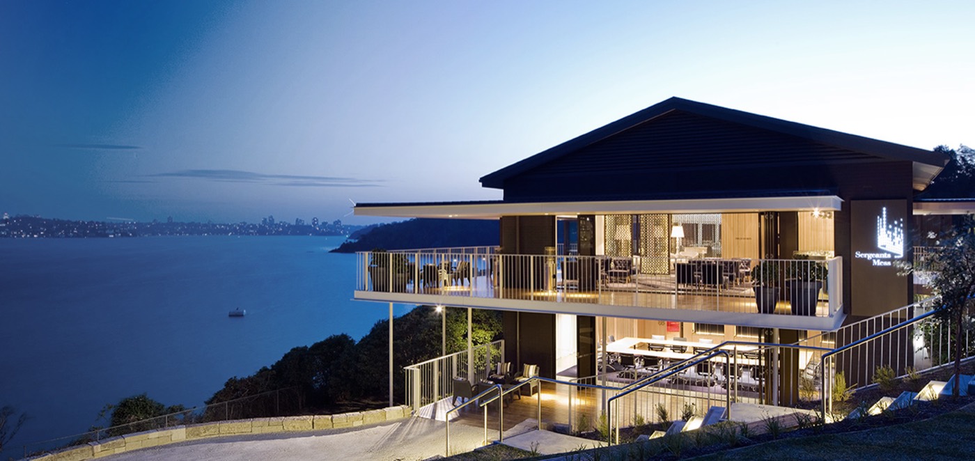 Sergeants' Mess lit up at dusk on the headland above Chowder Bay and the harbour
